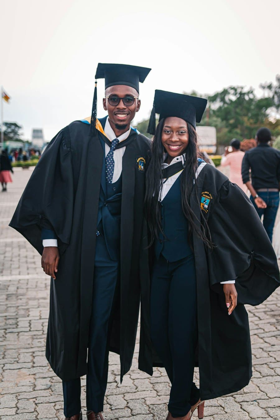 Two graduates in gowns smiling on graduation day
