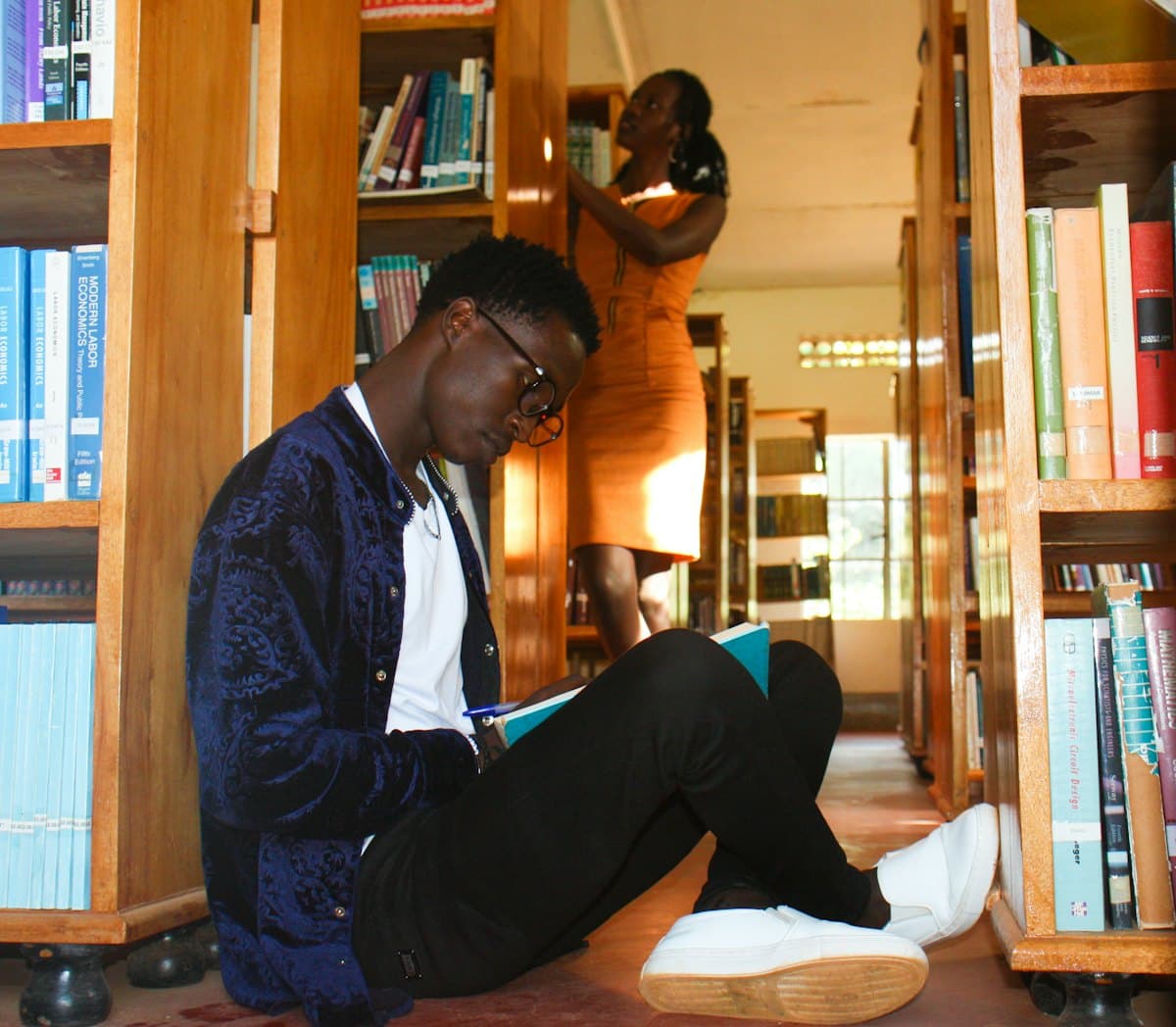 Student reading on the floor of a library
